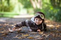 Little boy with aviator hat, lying on the ground in a park Royalty Free Stock Photo