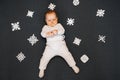 Little boy baby lying on the floor with homemade snowflakes