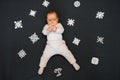 Little boy baby lying on the floor with homemade snowflakes