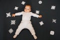 Little boy baby lying on the floor with homemade snowflakes