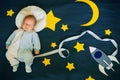 Little boy baby sleeping in a suit of the astronaut on the background of the starry sky with stars and a space ship Royalty Free Stock Photo