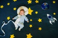 Little boy baby sleeping in a suit of the astronaut on the background of the starry sky with stars and a space ship Royalty Free Stock Photo