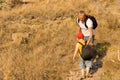 Little boy with a backpack climbing a mountain