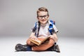 Little boy with backpack reading book in yoga pose Royalty Free Stock Photo