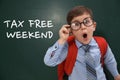 Boy with backpack and text TAX FREE WEEKEND written on chalkboard Royalty Free Stock Photo