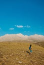 a little boy with a backpack walks along a path against the backdrop of mountains. travel with children to the mountains. Turkey. Royalty Free Stock Photo