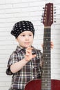 Little boy in bandana holding a guitar