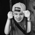 Angry emotional boy behind iron bars. Kid on an excursion in an old castle