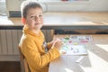 Little boy being creative making homemade do it yourself  dinosaur mosaic. Supporting creativity, learning by doing, learning Royalty Free Stock Photo
