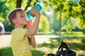 Little boy with bicycle drinks water in park Royalty Free Stock Photo