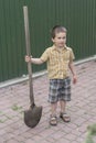 Little boy with a big shovel. little happy boy working with shovel in garden. boy 5 years old keeping a big shovel Royalty Free Stock Photo