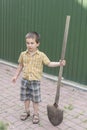 Little boy with a big shovel. little happy boy working with shovel in garden. boy 5 years old keeping a big shovel Royalty Free Stock Photo