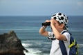 Little boy with binoculars exploring seascape