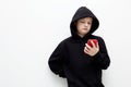 Little boy in a black hood with a smartphone