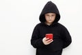 Little boy in a black hood with a smartphone