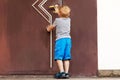 Caucasian baby boy tries to open the big door. Royalty Free Stock Photo