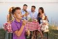 Little boy blowing outdoors. Picnic time