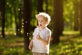 Little boy blows down dandelion fluff. Making a wish