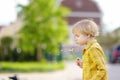 Little boy blows down dandelion fluff. Making a wish. Kids`s fun in the summer outdoors. Activity for inquisitive child Royalty Free Stock Photo