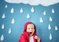 Little boy on blue background in coat with drop shapes Royalty Free Stock Photo