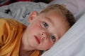 Little boy with blue eyes in bed Royalty Free Stock Photo