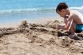 little boy in blue sea and play with sand Royalty Free Stock Photo