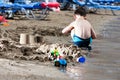 Little boy in blue sea and sand play Royalty Free Stock Photo