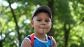 Little boy in blue T-shirt and hat in the park