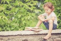 Little boy with book sitting in the park Royalty Free Stock Photo