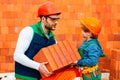 Little boy bricklayer. Brothers are building together. Brbuilder work with brick layer Royalty Free Stock Photo