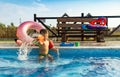 Boy with armbands playing with toys near the pool with clear water on the background of a summer sunset Royalty Free Stock Photo