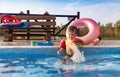 Boy with armbands playing with toys near the pool with clear water on the background of a summer sunset Royalty Free Stock Photo