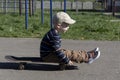 A little boy learns extreme sports, skateboarding in the summer on the playground, in the park and outdoors