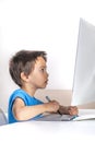 Little boy browses the internrt on a  desktop computer with graphics tablet. Modern lifestyle Royalty Free Stock Photo