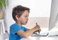 Little boy browses the internrt on a  desktop computer with graphics tablet. Modern lifestyle Royalty Free Stock Photo