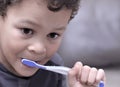 little boy brushing his teeth with tooth brush stock image with grey background with people stock photo