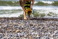 Little Boy with a Bucket playing with stones and sand at the beach Royalty Free Stock Photo