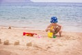 A little boy builds sand castles on the seashore. Royalty Free Stock Photo