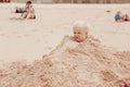 Little boy buried in pile of sand on the beach Royalty Free Stock Photo