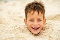 Little boy buried in the sand on beach Royalty Free Stock Photo