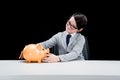 Little boy businessman sitting at table with piggy bank Royalty Free Stock Photo