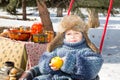 Little boy in a cap with earflaps plays winter park. Royalty Free Stock Photo