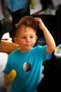 Little blonde boy with cap on eating a yellow popsicle Royalty Free Stock Photo