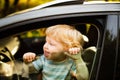 Little boy in the car, looking out of window, waving. Royalty Free Stock Photo