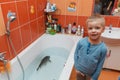 Little boy and carp in the bathtub.