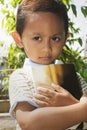 A little boy carrying a book with eyes looking ahead Royalty Free Stock Photo