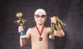 Little boy celebrates his golden trophy in swimming