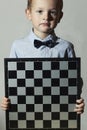 Little boy with chessboard.fashion children.Little genius Child.Intelligent