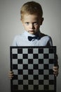 Little boy with chessboard.Intelligent game.Emotion. Serious Royalty Free Stock Photo