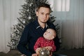 Little boy child in the arms of his father on the background of the Christmas tree Royalty Free Stock Photo